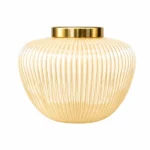 گلدان شیشه‌ای دکوراتیو رومیزی مدل ژاکلین سایز 16 و 20؛ تلفیقی از ظرافت، سادگی و طراحی لوکس اگر به دنبال یک گلدان شیشه‌ای خاص با طراحی متفاوت و ظاهری چشم‌نواز برای تکمیل دکوراسیون منزل یا محل کار خود هستید، گلدان شیشه‌ای دکوراتیو رومیزی مدل ژاکلین سایز 16 و 20 می‌تواند انتخابی ایده‌آل باشد. این گلدان با فرم گرد و ظریف، خطوط برجسته عمودی روی بدنه، رنگ کرم مرواریدی و لبه طلایی براق، ترکیبی زیبا از سبک مدرن و کلاسیک را ارائه می‌دهد. طراحی ساده اما شیک این مدل باعث شده تا بدون ایجاد شلوغی، جلوه‌ای لوکس به فضای شما اضافه کند. مدل ژاکلین در دو سایز 16 سانتی‌متر و 20 سانتی‌متر عرضه شده است که امکان استفاده به‌صورت تکی یا ترکیبی را فراهم می‌کند. قرار دادن این دو سایز در کنار هم، یک چیدمان هماهنگ و حرفه‌ای ایجاد کرده و باعث جذاب‌تر شدن دکوراسیون می‌شود. طراحی خاص با خطوط برجسته و فرم چشم‌نواز یکی از ویژگی‌های برجسته گلدان شیشه‌ای دکوراتیو رومیزی مدل ژاکلین سایز 16 و 20، طراحی بدنه آن است. خطوط عمودی ظریف که از قسمت بالایی تا پایین گلدان امتداد دارند، باعث ایجاد بافتی زیبا و منظم شده‌اند. این شیارها هنگام برخورد نور، انعکاس‌های ملایمی ایجاد می‌کنند و باعث می‌شوند سطح گلدان درخشش خاصی داشته باشد. فرم گرد و متناسب این گلدان حس لطافت و آرامش را به محیط منتقل می‌کند. این طراحی باعث شده مدل ژاکلین هم برای فضاهای مینیمال مناسب باشد و هم در دکوراسیون‌های لوکس و کلاسیک جلوه‌ای زیبا داشته باشد. رنگ کرم مرواریدی بدنه در کنار لبه طلایی دهانه، ترکیبی گرم و چشم‌نواز ایجاد کرده است که به‌راحتی با رنگ‌های مختلف دکوراسیون مانند سفید، کرم، طلایی، چوبی، طوسی و بژ هماهنگ می‌شود. عرضه در دو سایز کاربردی گلدان شیشه‌ای دکوراتیو رومیزی مدل ژاکلین در دو اندازه مختلف تولید شده است تا بتوانید متناسب با فضای موردنظر خود انتخاب کنید. سایز 16 ارتفاع: 16 سانتی‌متر قطر دهانه: 7 سانتی‌متر این سایز برای فضاهای کوچک‌تر مانند میز عسلی، میز کنار تخت، شلف، میز آرایش یا گوشه‌های دکوراتیو بسیار مناسب است. سایز 20 ارتفاع: 20 سانتی‌متر قطر دهانه: 9 سانتی‌متر سایز بزرگ‌تر انتخابی مناسب برای میز جلو مبلی، کنسول، میز ناهارخوری یا فضاهایی است که نیاز به یک المان دکوراتیو چشمگیرتر دارند. استفاده از هر دو سایز در کنار یکدیگر، باعث ایجاد تعادل در چیدمان شده و جلوه‌ای حرفه‌ای‌تر به محیط می‌بخشد. مناسب برای انواع گل و شاخه‌های تزئینی یکی از مزایای مهم این گلدان شیشه‌ای دکوراتیو رومیزی، قابلیت استفاده برای انواع گل‌آرایی است. شما می‌توانید مدل ژاکلین را با گل‌های مختلف ترکیب کنید و هر بار ظاهر متفاوتی به فضای خود بدهید. این گلدان برای موارد زیر مناسب است: گل‌های طبیعی گل‌های مصنوعی گل‌های خشک شاخه‌های تزئینی پامپاس اکالیپتوس برگ‌های دکوراتیو گل‌های فصلی فرم گرد گلدان باعث می‌شود دسته گل‌ها حالت پرتر و زیباتری داشته باشند و به‌عنوان یک نقطه تمرکز در دکوراسیون دیده شوند. هماهنگ با سبک‌های مختلف دکوراسیون طراحی متعادل و رنگ خنثی گلدان شیشه‌ای دکوراتیو رومیزی مدل ژاکلین سایز 16 و 20 باعث شده این محصول با سبک‌های مختلف دکوراسیون هماهنگ باشد. این گلدان انتخابی مناسب برای: دکوراسیون مدرن سبک مینیمال دکوراسیون نئوکلاسیک چیدمان کلاسیک سبک لوکس دکوراسیون‌های روشن و آرام است. ترکیب رنگ کرم مرواریدی و طلایی، حس گرما و ظرافت را به محیط اضافه می‌کند و می‌تواند در کنار مبلمان روشن، میزهای چوبی یا اکسسوری‌های طلایی جلوه‌ای بسیار زیبا ایجاد کند. مناسب برای قسمت‌های مختلف منزل و محل کار به دلیل ابعاد کاربردی و طراحی زیبا، این گلدان را می‌توان در بخش‌های مختلف استفاده کرد: میز پذیرایی میز جلو مبلی کنسول ورودی منزل شلف‌های دکوراتیو کتابخانه میز کار اتاق خواب میز آرایش سالن زیبایی دفتر کار فضاهای تجاری لوکس حتی بدون قرار دادن گل، فرم زیبا و رنگ خاص این محصول باعث می‌شود به‌عنوان یک وسیله دکوراتیو مستقل، جلوه‌ای جذاب داشته باشد. کیفیت ساخت و ظاهر لوکس گلدان شیشه‌ای دکوراتیو رومیزی مدل ژاکلین سایز 16 و 20 با استفاده از شیشه باکیفیت ساخته شده و سطح براق آن زیبایی محصول را دوچندان کرده است. اجرای دقیق خطوط برجسته روی بدنه و پرداخت ظریف لبه طلایی، نشان‌دهنده توجه به جزئیات در طراحی این مدل است. این گلدان علاوه بر زیبایی ظاهری، دوام مناسبی دارد و با نگهداری صحیح می‌تواند برای مدت طولانی زینت‌بخش فضای شما باشد. انتخابی خاص برای هدیه اگر به دنبال هدیه‌ای شیک، کاربردی و متفاوت هستید، این مدل گزینه‌ای ارزشمند محسوب می‌شود. گلدان شیشه‌ای دکوراتیو رومیزی مدل ژاکلین سایز 16 و 20 می‌تواند برای مناسبت‌هایی مانند: هدیه تولد سالگرد ازدواج خانه نو جهیزیه عروس روز مادر روز زن هدیه سازمانی انتخابی زیبا و ماندگار باشد. چرا گلدان شیشه‌ای دکوراتیو رومیزی مدل ژاکلین سایز 16 و 20 را انتخاب کنیم؟ ویژگی‌های این محصول: طراحی ظریف و لوکس فرم گرد و چشم‌نواز بدنه دارای خطوط برجسته زیبا رنگ کرم مرواریدی جذاب لبه طلایی براق عرضه در دو سایز کاربردی مناسب برای گل طبیعی، مصنوعی و خشک قابل استفاده به‌صورت تکی یا ست هماهنگ با انواع سبک‌های دکوراسیون مناسب منزل، محل کار و هدیه راهنمای نگهداری از گلدان شیشه‌ای ژاکلین برای حفظ زیبایی و کیفیت این گلدان بهتر است: از آب ولرم و شوینده ملایم برای شست‌وشو استفاده شود. از اسکاچ زبر و مواد شوینده قوی استفاده نشود. پس از شست‌وشو با دستمال نرم خشک شود. از ضربه مستقیم به بدنه شیشه‌ای جلوگیری شود. برای حفظ درخشندگی لبه طلایی، از تماس طولانی با مواد شیمیایی خودداری شود. خرید گلدان شیشه‌ای دکوراتیو رومیزی مدل ژاکلین سایز 16 و 20 اگر قصد خرید یک گلدان شیشه‌ای دکوراتیو رومیزی شیک و خاص را دارید، گلدان شیشه‌ای دکوراتیو رومیزی مدل ژاکلین سایز 16 و 20 می‌تواند انتخابی مناسب برای زیباسازی فضای شما باشد. طراحی منحنی، خطوط برجسته ظریف، رنگ کرم مرواریدی و جزئیات طلایی، این محصول را به یک اکسسوری لوکس و کاربردی تبدیل کرده است. این گلدان با قابلیت استفاده در سبک‌های مختلف دکوراسیون، امکان انتخاب بین دو سایز و هماهنگی با انواع گل‌آرایی، گزینه‌ای مناسب برای افرادی است که به جزئیات دکوراسیون اهمیت می‌دهند و به دنبال محصولی متفاوت برای ایجاد فضایی زیباتر هستند.